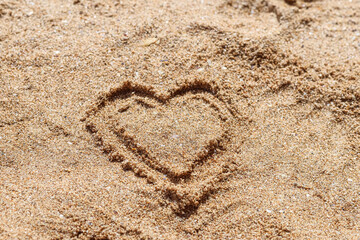 A heart drawn on the sand of a beach