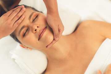 Panorama top view of woman enjoying relaxing anti-stress head massage and pampering facial beauty skin recreation leisure in dayspa modern light ambient at luxury resort or hotel spa salon. Quiescent