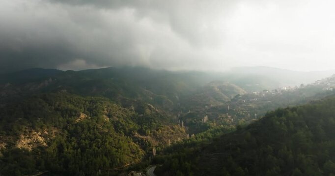 A panoramic aerial view opens up to a forested valley between mountain ridges. Mist and depth create layers of space and natural calm.. a perfect background for ecotourism and slow travel concepts