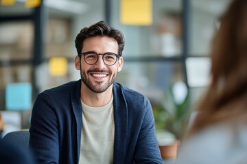 Obraz premium Engaging smiling man in casual attire during a collaborative meeting in a bright office