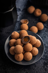 Chocolate truffles with cocoa powder and caramel filling on wooden table.