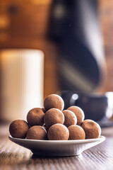 Chocolate truffles with cocoa powder on wooden table.