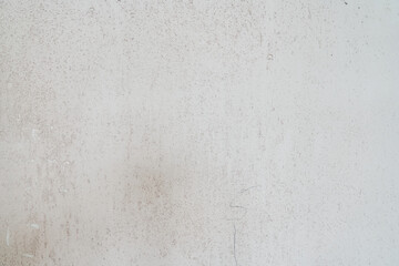 Obraz premium A dirty wall plastered with streaks. The uneven background with the texture of decorative plaster is exposed to atmospheric influences. Rough wall with space for copying. High quality photo