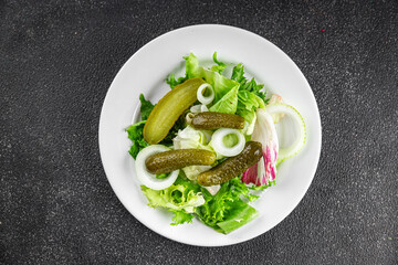 Pickle salad gherkins pickled cucumbers mixed green leaf lettuce appetizer vegetables dish organic fresh tasty gourmet food background on the table food top view copy space vegetarian vegan food