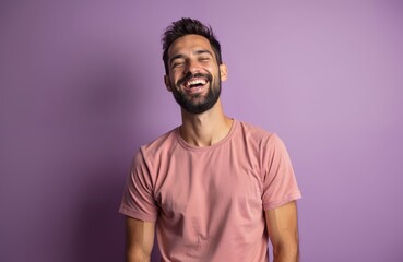Young man laughs. Happy smiling face, positive emotions, good mood on purple background. Joyful person, feeling happiness, fun, laughter, positive lifestyle. Caucasian male portrait. Studio shot.