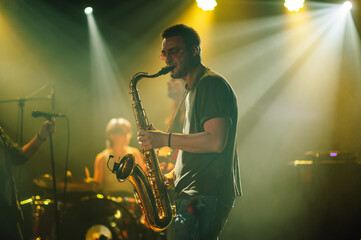 Saxophonist performing live on stage with band
