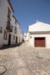 A narrow cobbled street in the historic village of Marvao, Portalegre district, Portugal, captured on a sunny day. Its whitewashed houses and medieval charm attract visitors year-round.