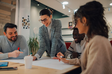 Smiling business team working on project in modern office