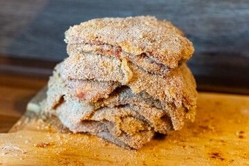 Crunchy fried delicacy prepared with seasoned flour on a wooden surface in a kitchen setting