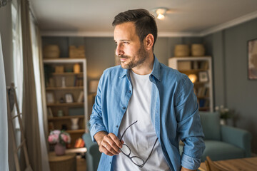 One adult man with eyeglasses stand at home happy smile