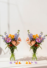 Fototapeta premium Pair of Colorful Spring Bouquets in Glass Vases