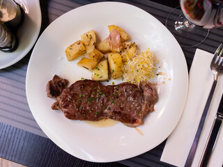 Grilled beef with fried potato served on table with serving pieces
