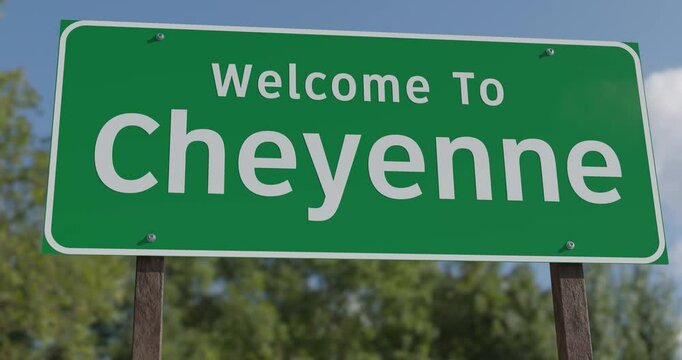 Driving By A Welcome To Cheyenne, Wyoming Green Road Sign Against a Blue Sky and Clouds - United States Capital Series.