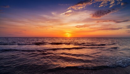 Obraz premium 7月の夕焼け、海と空が温かいオレンジ色に染まり、太陽がゆっくりと水平線に沈んでいく。穏やかな海面に反射する夕日の色が、心を満たす