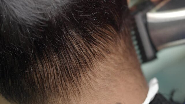 Hair stylist demonstrates precise hair cutting techniques at salon