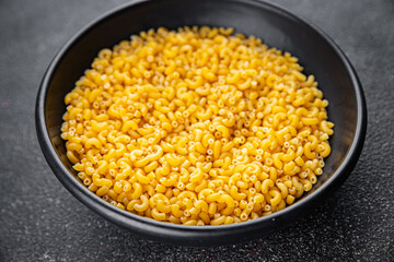 Macaroni pasta raw coquillette appetizer dish organic product fresh tasty gourmet food background on the table rustic food top view copy space