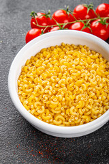 Macaroni pasta raw coquillette appetizer dish organic product fresh tasty gourmet food background on the table rustic food top view copy space