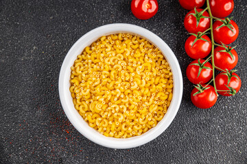 Macaroni pasta raw coquillette appetizer dish organic product fresh tasty gourmet food background on the table rustic food top view copy space