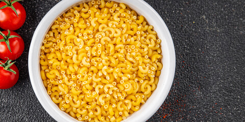 Macaroni pasta raw coquillette appetizer dish organic product fresh tasty gourmet food background on the table rustic food top view copy space
