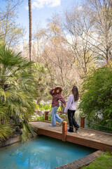 Friends joyfully enjoy natures beauty on a bridge in a vibrant, flowerfilled garden
