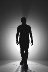 Obraz premium Dramatic silhouette of a man standing confidently against a bright, contrasting background, exuding strength and determination.