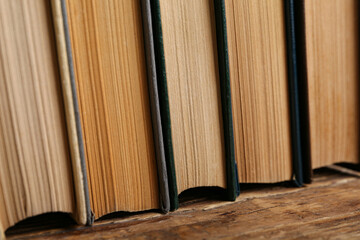 Stack of old hardcover books on wooden background, closeup