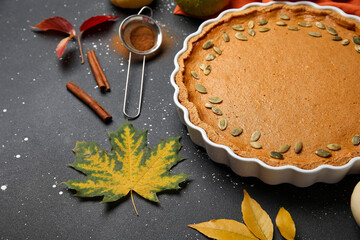 Baking dish with tasty pumpkin pie on black background