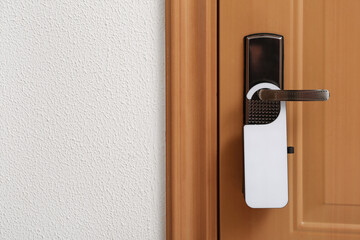 Modern wooden door with white hanger in hotel room