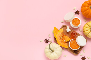 Jars of cosmetic pumpkin mask, seeds, star anise and bottle of oil on pink background