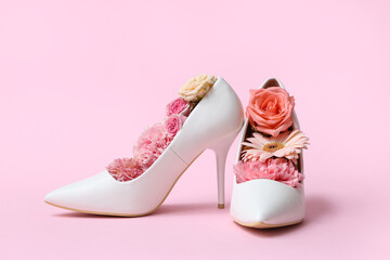 Composition with stylish female high-heeled shoes and beautiful flowers on pink background © Pixel-Shot