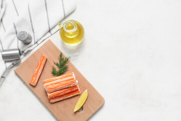 Wooden board with tasty crab sticks, dill and piece of lemon on white background © Pixel-Shot