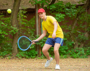 teenager playing with a racket and a ball