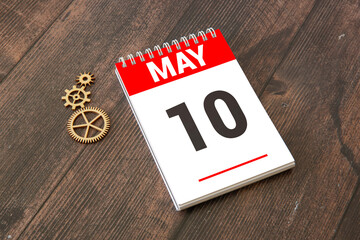 Wooden block calendar with date May 10 on a concrete background
