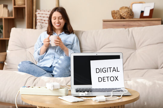 Paper with text DIGITAL DETOX and gadgets on table against woman resting at home, closeup. National Day of Unplugging