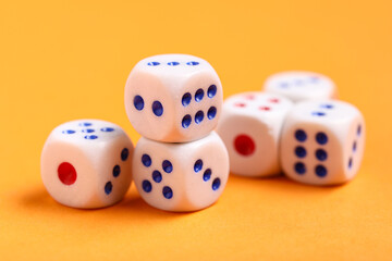 White game dices on orange background, closeup