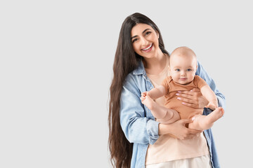 Happy mother with her little baby on light background