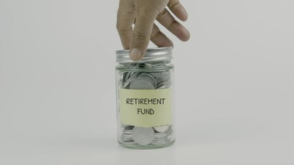 Retirement Fund text or word on yellow sticky notes on a coin jar, hand inserting a coin and sealing the lid, symbolizing long-term savings for retirement on a white background