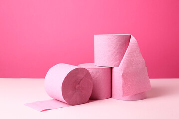 Color toilet paper rolls on pink background. Space for text