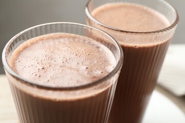 Tasty chocolate milk in glasses on table, closeup