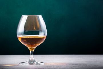 French cognac Superior in snifter glass on dark green background