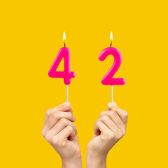Birthday number 42 - Hands holding fuchsia colored candles