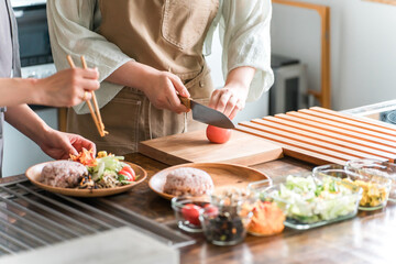 料理教室・クッキングスクールで料理を教える講師の女性と生徒の女性

