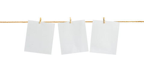 Blank paper hanging on a rope with an isolated clothespin on a white background © Wildaanun