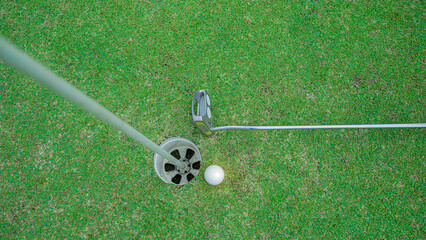 Obraz premium Golf ball and golf club on green in the evening golf course.