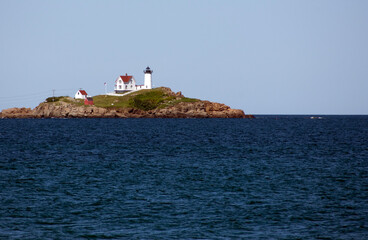 Landscape shot of a large lighthouse on the coast of Maine.