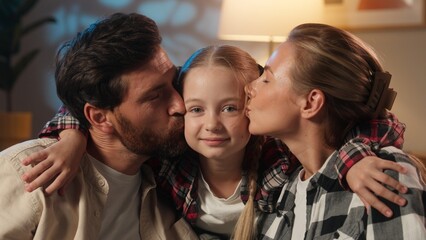 Happy portrait of European family parents kissing daughter in cheeks love kiss parenting concept love bonding affectionate smiling looking at camera satisfied parents with child girl kid adopt custody