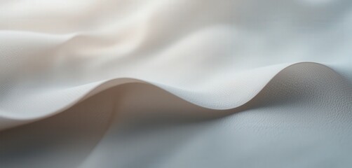 Fototapeta premium A close-up view of soft, white fabric showcasing its delicate texture and intricate weave, with gentle light illuminating the subtle variations in shade and pattern.