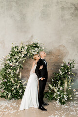 Young beautiful happy couple hugging and smiling near the arch