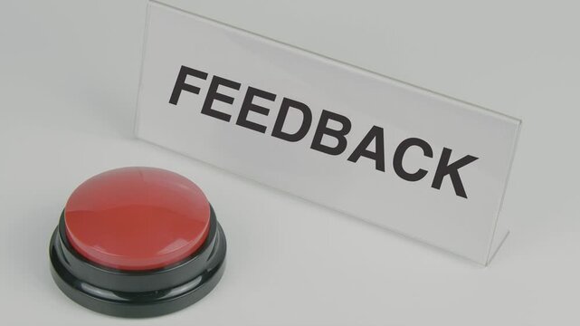 Feedback text or word, symbolizing response, communication, and evaluation, displayed on a nameplate as a hand presses a red button set against a white background