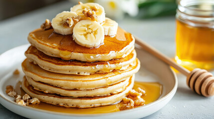 Delicious Stack of Pancakes with Sliced Bananas, Honey, and Chopped Nuts on a Plate